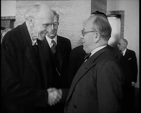 Two Male League of Nations Delegates Greeting Each Other By Shaking Hands While Two Other..., 1937. Creator: British Pathe Ltd.