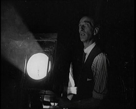 Male Civilian Stands Next to a Large Light, 1920s. Creator: British Pathe Ltd.