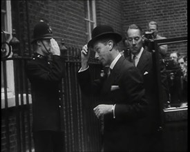 A Male British Police Officer Saluting King George VI, the British Monarch who is Exiting..., 1939. Creator: British Pathe Ltd.