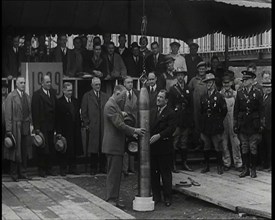 Two British Men Guiding a Time Capsule Being Lowered in the Ground With Various Civilians..., 1938. Creator: British Pathe Ltd.