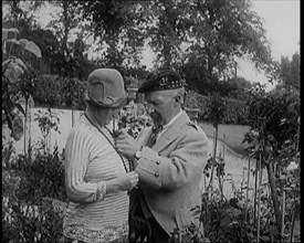 Sir Harry Lauder Giving Flowers to His Wife, Lady Ann Lauder, at Home in Scotland, 1920s. Creator: British Pathe Ltd.