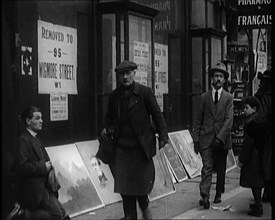 Male Ex-Services Civilian Selling Paintings on a Pavement Whilst Other Civilians are Walk..., 1920s. Creator: British Pathe Ltd.