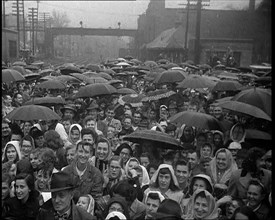 Masses of People Cheering the Train As It Passes By Many Have Umbrellas As It Is Raining, 1932. Creator: British Pathe Ltd.