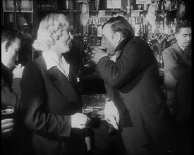 A British Woman and a British Man Standing at  the Bar Holding Drinks in a Public House..., 1939. Creator: British Pathe Ltd.