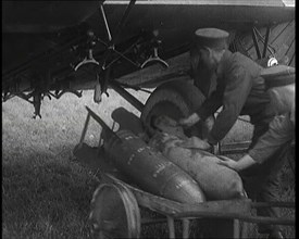 Male British Officers Loading Bombs Onto a Plane, 1920s Creator: British Pathe Ltd.