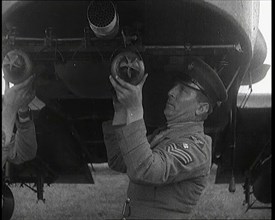 Male British Officers Mounting Bombs Into a Fighter Plane, 1920s. Creator: British Pathe Ltd.