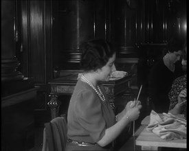 Queen Elizabeth Knitting at a Large Sewing Group Hosted in Buckingham Palace, 1940. Creator: British Pathe Ltd.