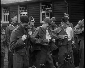 Male British Soldiers Putting on The Tunics of Their Uniforms in Front of Wooden Hut, 1939. Creator: British Pathe Ltd.