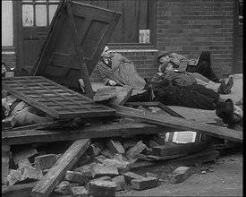 British People Acting Out Bomb attacks and Crashed German Planes, Lying Under Rubble, 1940. Creator: British Pathe Ltd.