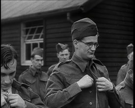 Close up on a Male British Soldier Wearing a Side Cap and Round-Rimmed Glasses Buttoning up..., 1939 Creator: British Pathe Ltd.