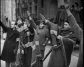 Armed Men and Civilians Making Fascist Salutes in a Street in Madrid, All Dressed in Thick..., 1939. Creator: British Pathe Ltd.