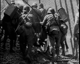 A Group of Male Japanese Soldiers Pushing a Gun Over Rubble in a Street in Shanghai, 1937. Creator: British Pathe Ltd.