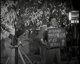 Female Actor Sitting in a Blossom Tree Whilst a Male Civilian Talks to Her..., 1920s. Creator: British Pathe Ltd.