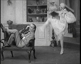 Renee Gadd Dancing Around George Grossmith Who Is Desperately Trying to Make a Phone Call..., 1920s. Creator: British Pathe Ltd.