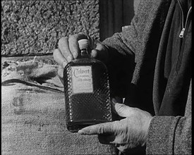 A Man Holding a Bottle of Liquor, 1932. Creator: British Pathe Ltd.