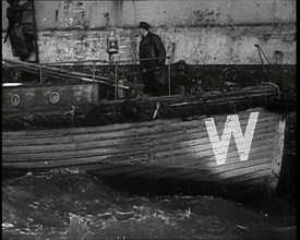 Small Wooden Customs Boat With Male Crew Member Standing at  the Bow End Alongside..., 1939. Creator: British Pathe Ltd.