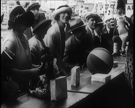 A Crowd of People Playing a Game Where They Have to Pop a Balloon By Turning a Handle, 1924. Creator: British Pathe Ltd.