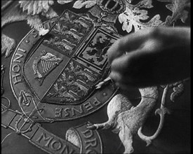 Hand of Seamstress Sewing a Royal Emblem, 1937. Creator: British Pathe Ltd.