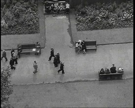 An Overhead Shot of Pedestrians Walking up and Down a Path or Sitting on Benches in a Park..., 1938. Creator: British Pathe Ltd.