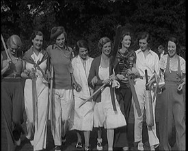 Female Civilians Carrying Cricket Bats Walking in a Line, 1920s. Creator: British Pathe Ltd.