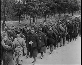 Male Polish Soldiers Walking Along an Unpaved Road Beside a Line of Trees With Fences Beyond, 1939. Creator: British Pathe Ltd.