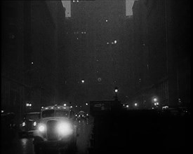 A Car Driving Towards the Camera With Very Bright Head Lights On the Streets of New York..., 1932. Creator: British Pathe Ltd.