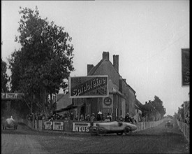 A Racing Circuit As Racing Cars Drive By. Signs On a Building Read: 'Spidoleine Huile' and..., 1924. Creator: British Pathe Ltd.