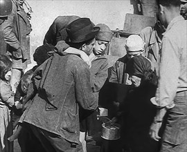 Italian Civilians Getting Assistance from American Soldiers in a Bomb-Damaged Italian Town, 1943-44. Creator: British Pathe Ltd.