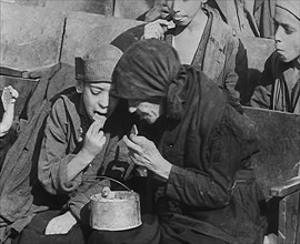 Italian Civilians Eating Food in a Bomb-Damaged Italian Town, 1943-1944. Creator: British Pathe Ltd.