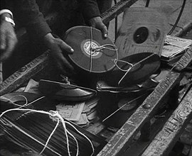 A Man Dumping Old gramophone records to Use for War Materials, 1942. Creator: British Pathe Ltd.