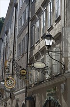 Detail view of the traditional signs along an old building on Getreidegasse, Salzburg, Austria, 2022 Creator: Ethel Davies.