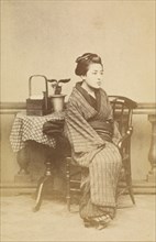 Woman sitting by table, about 1868. Creator: Felice Beato.