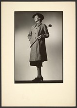 Woman modeling coat with golf club, early 1940s. Creator: Gunther Krampf.