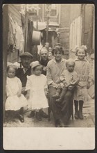 Family portrait in tenement alley, about 1913-1925. Creator: John Frank Keith.