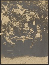 Group portrait around table, 1880-1890. Creator: Victor Dix.