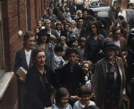 British Women and Child Evacuees Walking Along the Pavement of a Residential Street Next..., 1939. Creator: British Pathe Ltd.