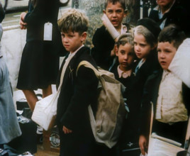 British Child Evacuees Standing on a Pavement With Bags and Boxes as Adults are Standing..., 1939. Creator: British Pathe Ltd.