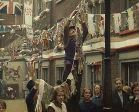 Man Hanging Bunting from a Lamp Post in a Street With Decorations For the Coronation of..., 1937. Creator: British Pathe Ltd.