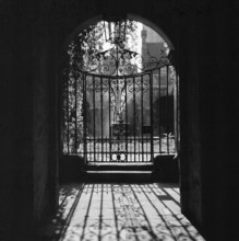 View looking through a decorative wrought iron gate in the Little Cloister at Westminster Abbey,