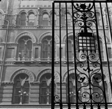 Looking up past the ornate iron gates of Westminster Palace Gardens to the facade of the Army and
