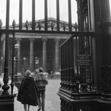 Visitors around the wrought iron gates at the south entrance to the British Museum, London,