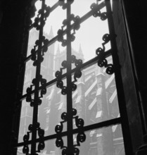 Looking through a wrought iron decorative window grille towards the south facade of the Westminster