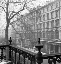 Looking along the side of a lightly-snowy London square from a raised position behind a