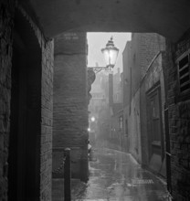 A dimly lit alley in London's theatre land off St Martin's Lane, early 1960s. Image featured in
