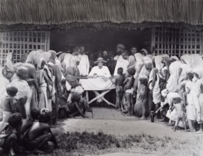 Paying wages to tea estate labourers, Bengal, 1880s. A European distributes pay to Indian workers,