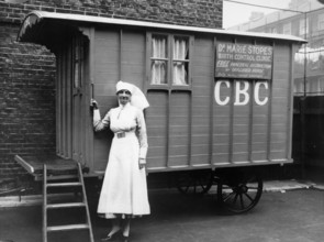 Nurse outside a Marie Stopes mobile birth control clinic, Bethnal Green, London, 1928. 'Free