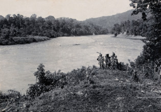 Sarawak: three men standing by the Baram River, c1900. Creator: Unknown.