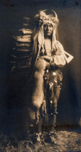 A Piegan man, Iron Breast, in ceremonial dress, 1900. Creator: Edward Sheriff Curtis.