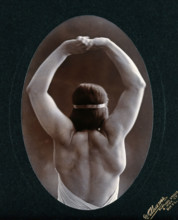 A young woman posing semi-naked, back view, with her arms in the air, in a photographic..., c1903. Creator: Unknown.