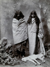 A man and woman of the Toda tribe standing in a photographic studio, with a dog lying..., c1900. Creator: Unknown.